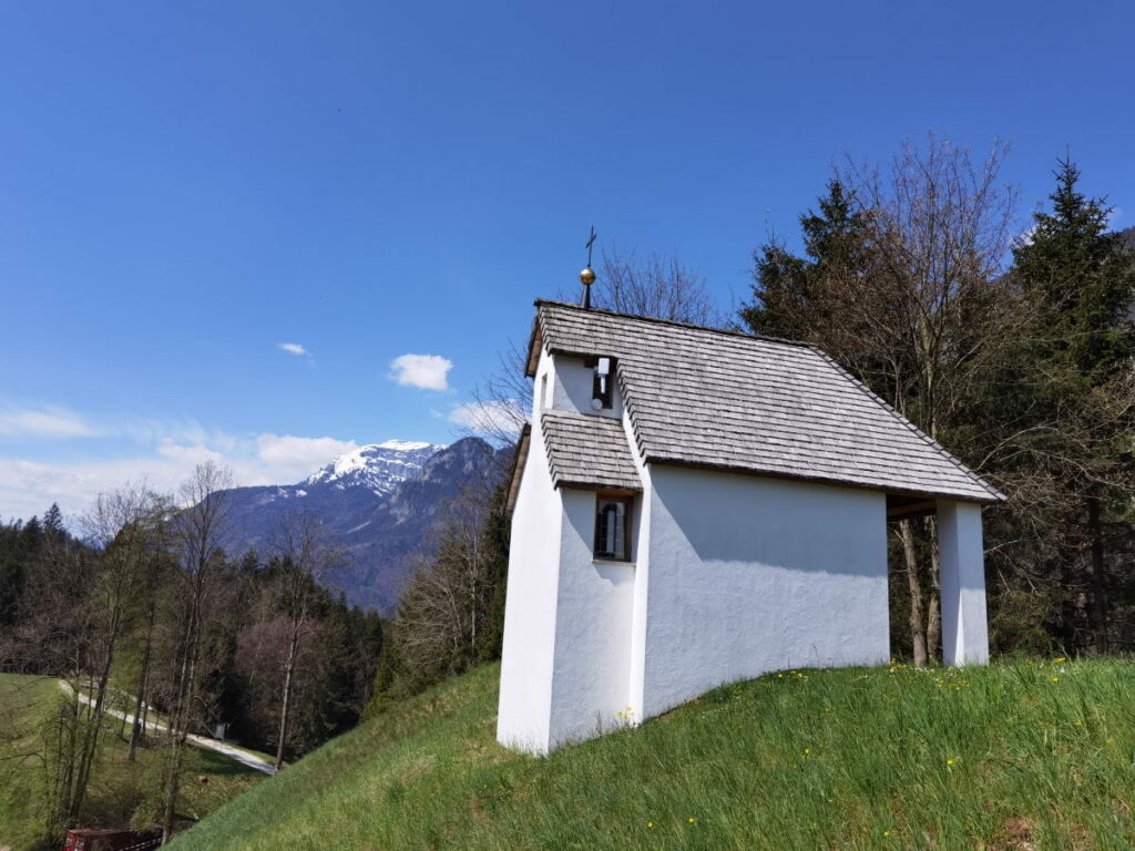 Die Antoniuskapelle am Reintalersee, hinten die schneebedeckten Berge im Rofan